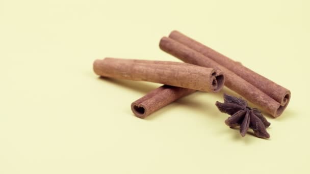 Cinnamon sticks and anise star on a yellow background. — Stock Video