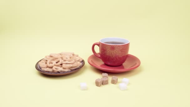 Chá com biscoitos e açúcar em um fundo amarelo . — Vídeo de Stock