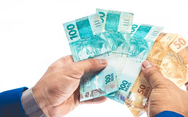Gerçek para birimi. Dinheiro, Brasil, Money, Reais. Elinde 100 Brezilyalı banknot tutan adam.