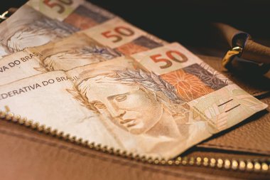 Brezilyalı Real. Brezilya 'dan gelen para. Kadın çantasında 50 Reais banknotları.