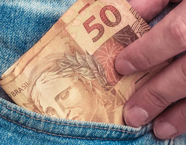 Real Currency. Dinheiro, Brasil, Money, Reais. Money from Brazil. Banknotes of the Brazilian real in a trouser pocket.