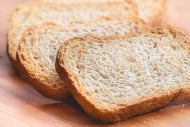wholemeal toast ( torrada integral ) in close-up on a wooden board.