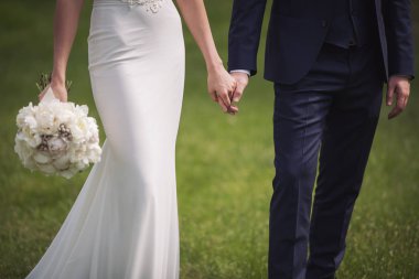 Gelinin elinde bir buket çiçek var. Güzel bir buket çiçek..