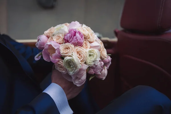 wedding bouquet of flowers in the hands of the groom. Beautiful wedding bouquet of flowers.