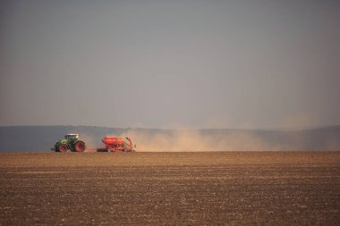 Traktördeki çiftçi gelecek yıl için tohum yatağıyla toprağı hazırlıyor..