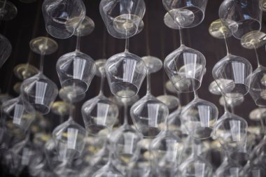 Boş şarap kadehleri siyah arka planda asılı duruyor..