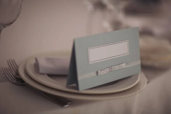 結婚式の席テーブルの上にはナプキンとカードとグラスが置かれています レストランやホテルのエレガントなディナーテーブルの設定 — ストック写真