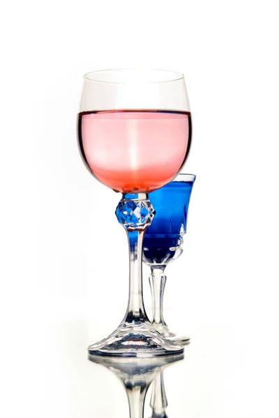 Vino rosa y cóctel azul en hermosas copas de cristal vintage sobre fondo blanco de la pared, con espacio para copiar. Lista de vinos, carta de bebidas, boutique de vinos o degustación, concepto de cultivo vertical — Foto de Stock