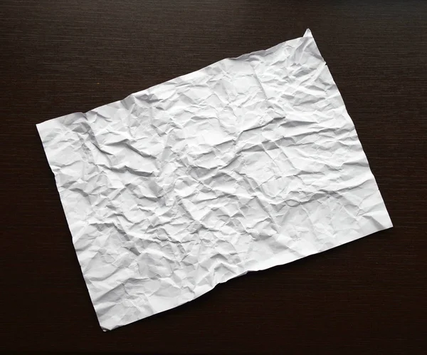 Bílý abstraktní zmačkaný papír na tmavém dřevěném stole. Starý papír textury pozadí pro design, pozvání, dekorativní papírové textury konceptu. Horní pohled — Stock fotografie