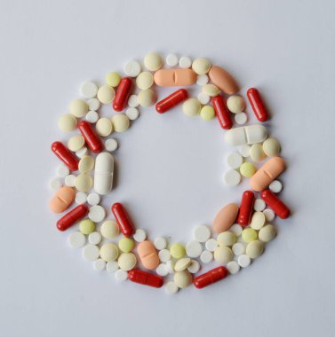 Eczacılık çeşitli ilaç hapları, tabletler ve yuvarlak kapsüller. Beyaz arkaplanda farklı renkte tablet. Boşluğu Kopyala ile üst görünüm