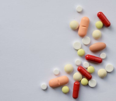 Eczacılık çeşitli ilaç hapları, haplar ve kapsüller. Beyaz arkaplanda farklı renkte tablet. Boşluğu Kopyala ile üst görünüm