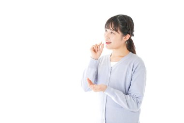 Genç Asyalı kadın beyaz arka planda izole edilmiş haplar alıyor.