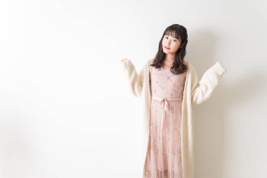 Beyaz arka planda izole edilmiş pembe elbiseli Asyalı genç kadın portresi.