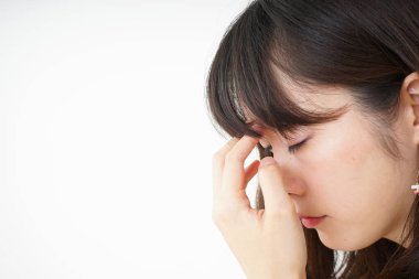 Baş ağrısı olan genç bir kadın, beyaz arka planda izole edilmiş.