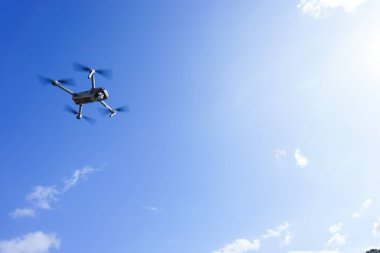 Mavi gökyüzüne karşı uçan dron
