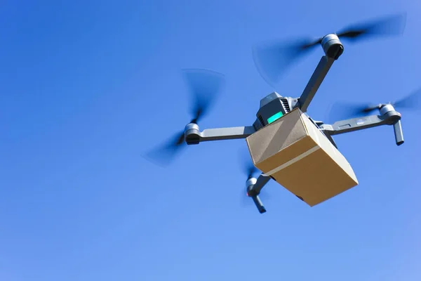 Mavi gökyüzüne karşı uçan drone taşıyor, İHA teslimatı