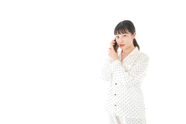 Pijamalı Asyalı Genç Bir Kadın Telefonda Konuşuyor Beyaz Bir Arka — Stok fotoğraf