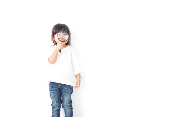 Küçük Asyalı Kız Elinde Büyüteç Beyaz Arka Planda Izole Edilmiş — Stok fotoğraf