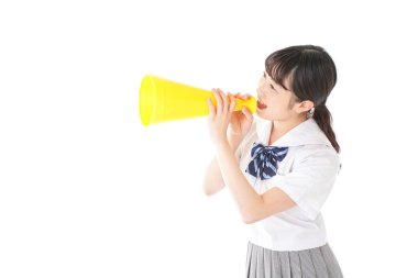 Beyaz arka planda izole edilmiş sarı megafonlu Asyalı genç kadının portresi.