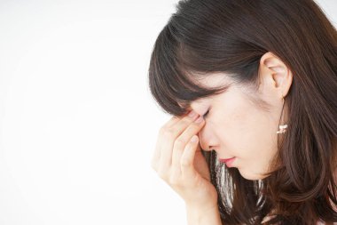 Baş ağrısı olan genç bir kadın, beyaz arka planda izole edilmiş.