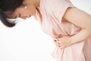 Beyaz arka planda karın ağrısı çeken bir kadın.