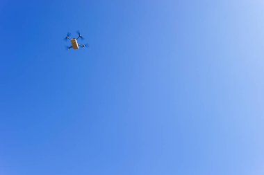 Mavi gökyüzüne karşı uçan drone taşıyor, İHA teslimatı