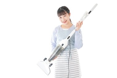 Elektrikli süpürgesi olan Asyalı kadın beyaz arka planda izole edilmiş.