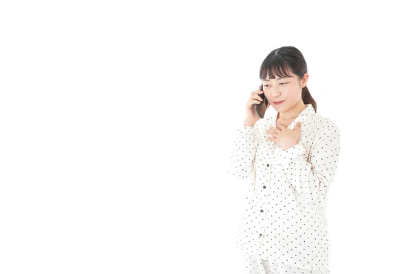 Pijamalı Asyalı Genç Bir Kadın Telefonda Konuşuyor Beyaz Bir Arka — Stok fotoğraf