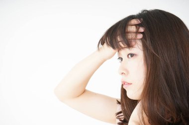 Baş ağrısı olan genç bir kadın, beyaz arka planda izole edilmiş.