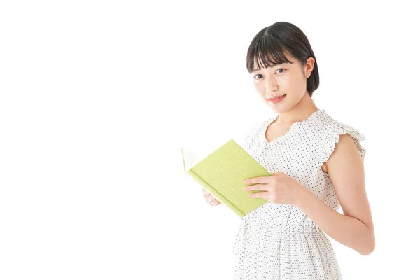 アジアの若い女性が白い背景で隔絶された本を読んでいる姿 — ストック写真