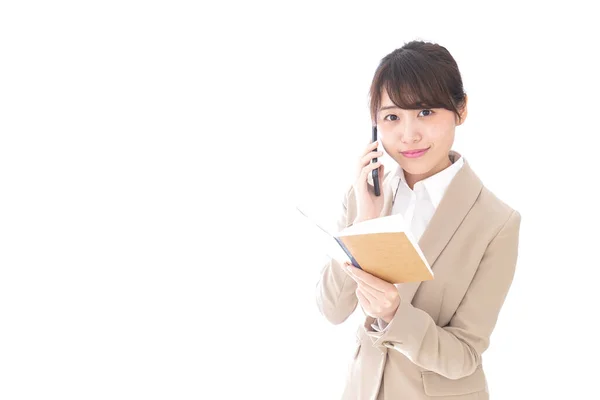Defterli Asyalı Kadını Beyaz Arka Planda Cep Telefonuyla Konuşuyor — Stok fotoğraf