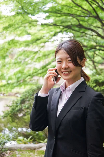 공원에서 전화로 통화하는 아시아 여성의 — 스톡 사진