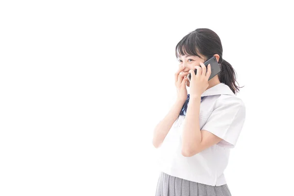 電話で話す制服姿のアジア系の若い女性の肖像画です — ストック写真