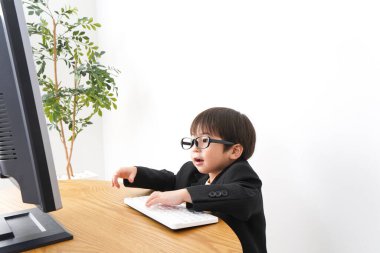 küçük çocuk masaüstü bilgisayarı kullanarak çalışıyor 