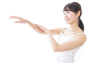Beyaz arka planda izole edilmiş Asyalı genç bir kadının kollara dokunuşunun portresi.