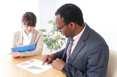 Genç iş adamları masada iş grafiklerini tartışıyor. 