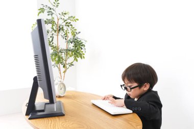 küçük çocuk masaüstü bilgisayarı kullanarak çalışıyor 