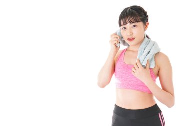 Beyaz arka planda, terini havluyla silen kadın.