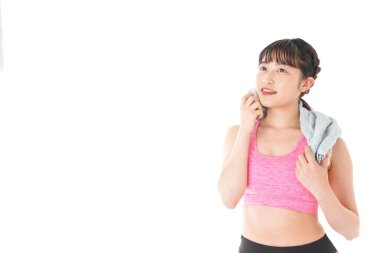 Beyaz arka planda, terini havluyla silen kadın.