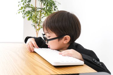 küçük çocuk masaüstü bilgisayarı kullanarak çalışıyor 