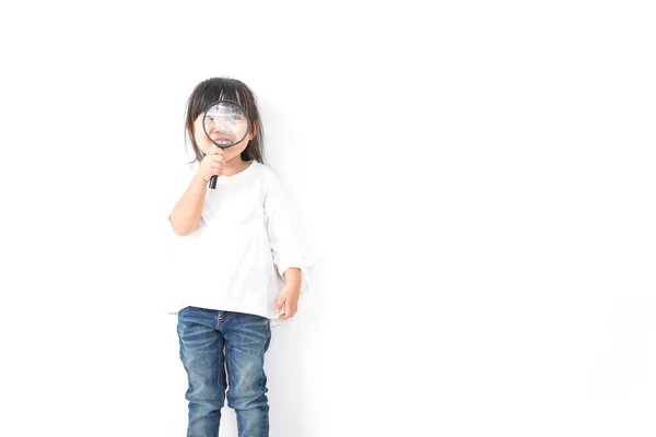 Küçük Asyalı Kız Elinde Büyüteç Beyaz Arka Planda Izole Edilmiş — Stok fotoğraf