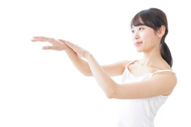 Beyaz arka planda izole edilmiş krem süren Asyalı genç kadın portresi