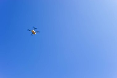 Mavi gökyüzüne karşı uçan drone taşıyor, İHA teslimatı