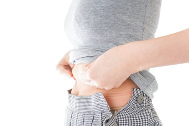 Karnına dokunan kadının yakın çekimi.