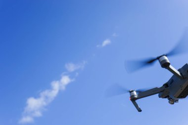 Mavi gökyüzüne karşı uçan dron
