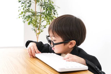 küçük çocuk masaüstü bilgisayarı kullanarak çalışıyor 