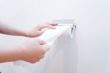 Beyaz arka planda tuvalet kağıdı alan kadın elleri