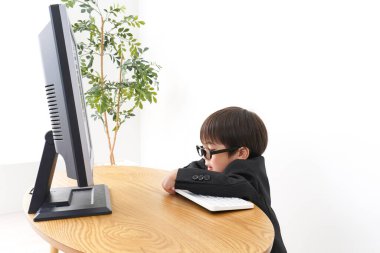 küçük çocuk masaüstü bilgisayarı kullanarak çalışıyor 