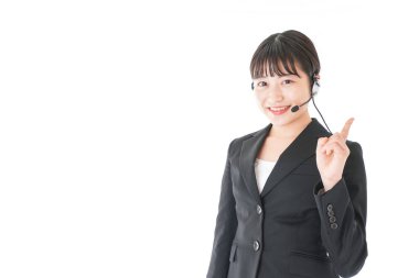 İş yerinde kulaklığı olan Asyalı iş kadını beyaz arka planda, müşteri hizmetlerinde izole edilmiş. 