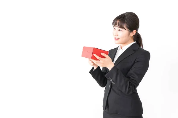 亚洲女商人的画像 身穿黑色西服 手持白色背景的礼品盒 — 图库照片